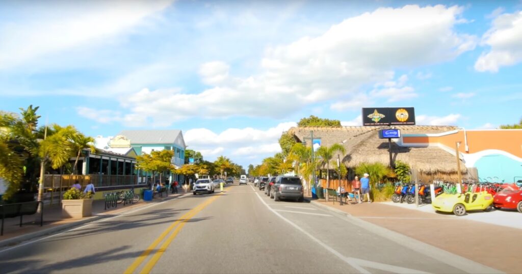 View of the street with parked cars and people